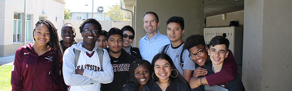 A group of students pose for a photo with Eastside principal Chris Bischof